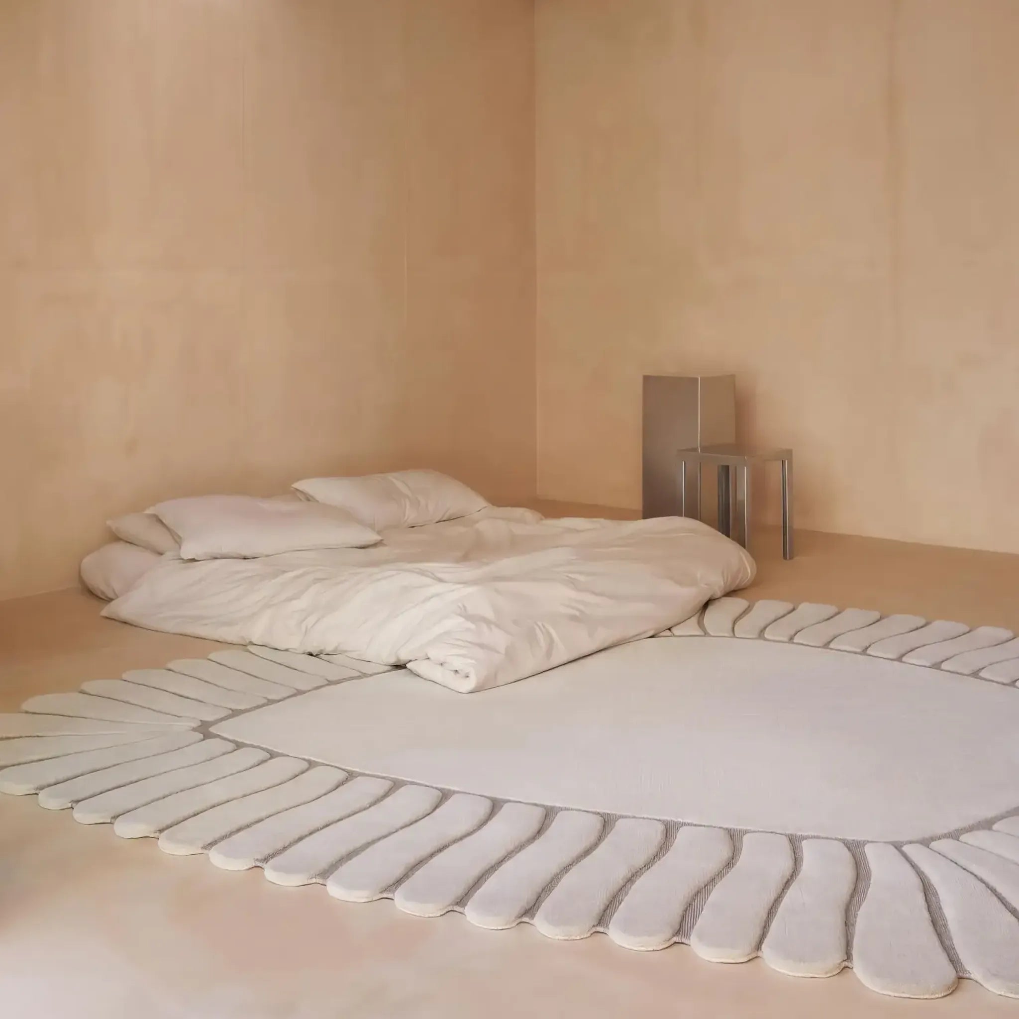 Minimalist bedroom with beige walls, a bed, and Coquille Cream Seashell Shaped Sculpted Rug by Housenfriends