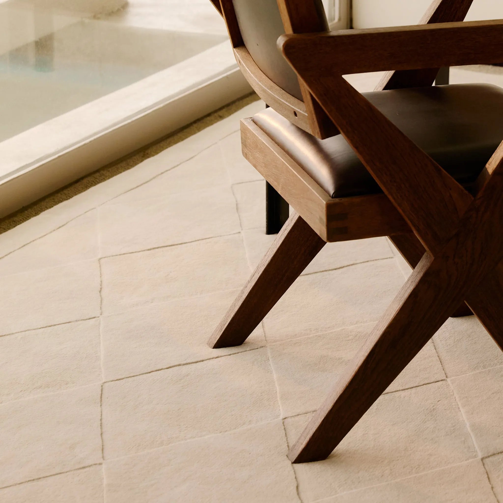 Wooden chair on the Cream Diamond Modern High Low Hand Tufted Rug by Housenfriends
