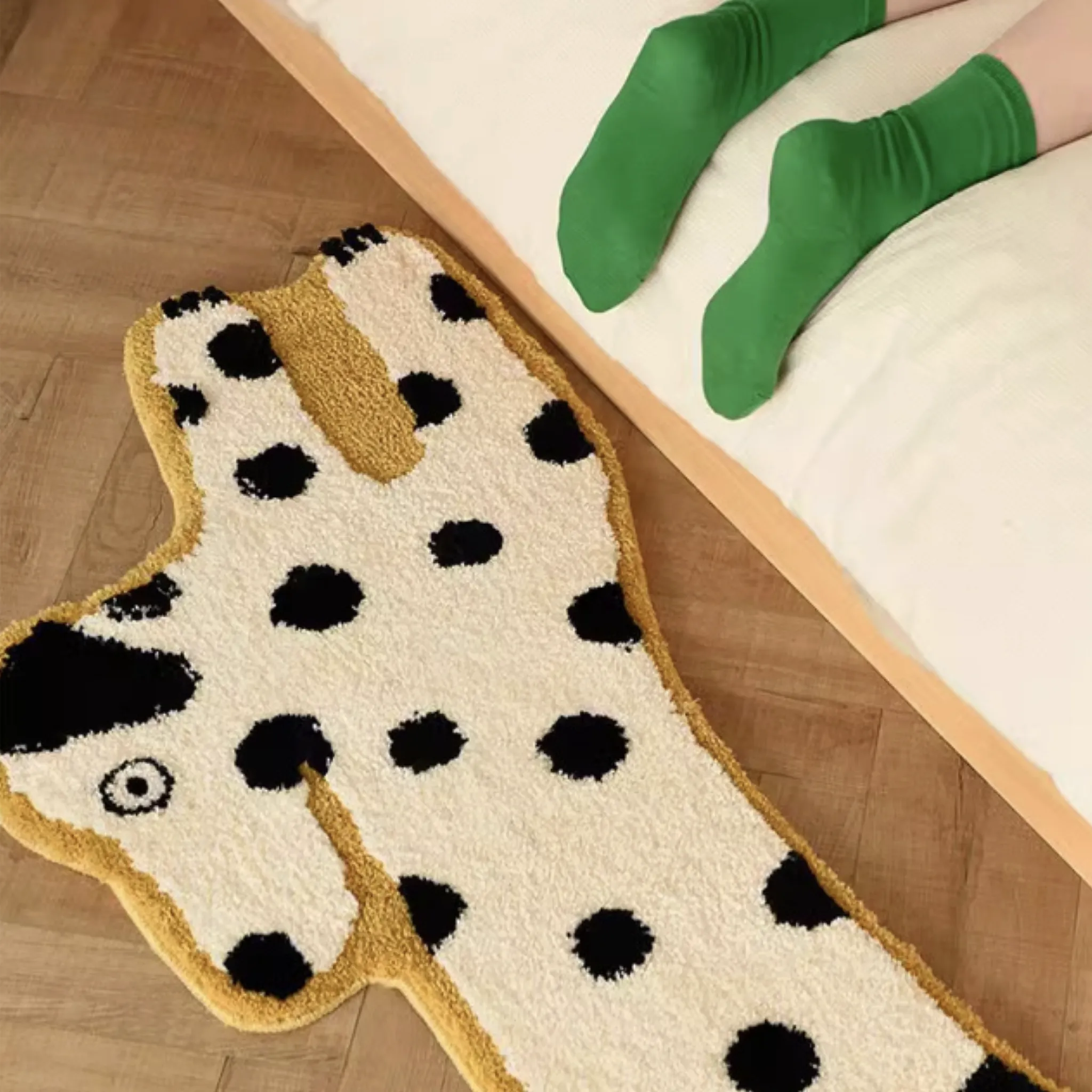 Dalmatian Yellow Outlined White Dog Shaped Tufted Rug on a wooden floor, next to a person wearing green socks.