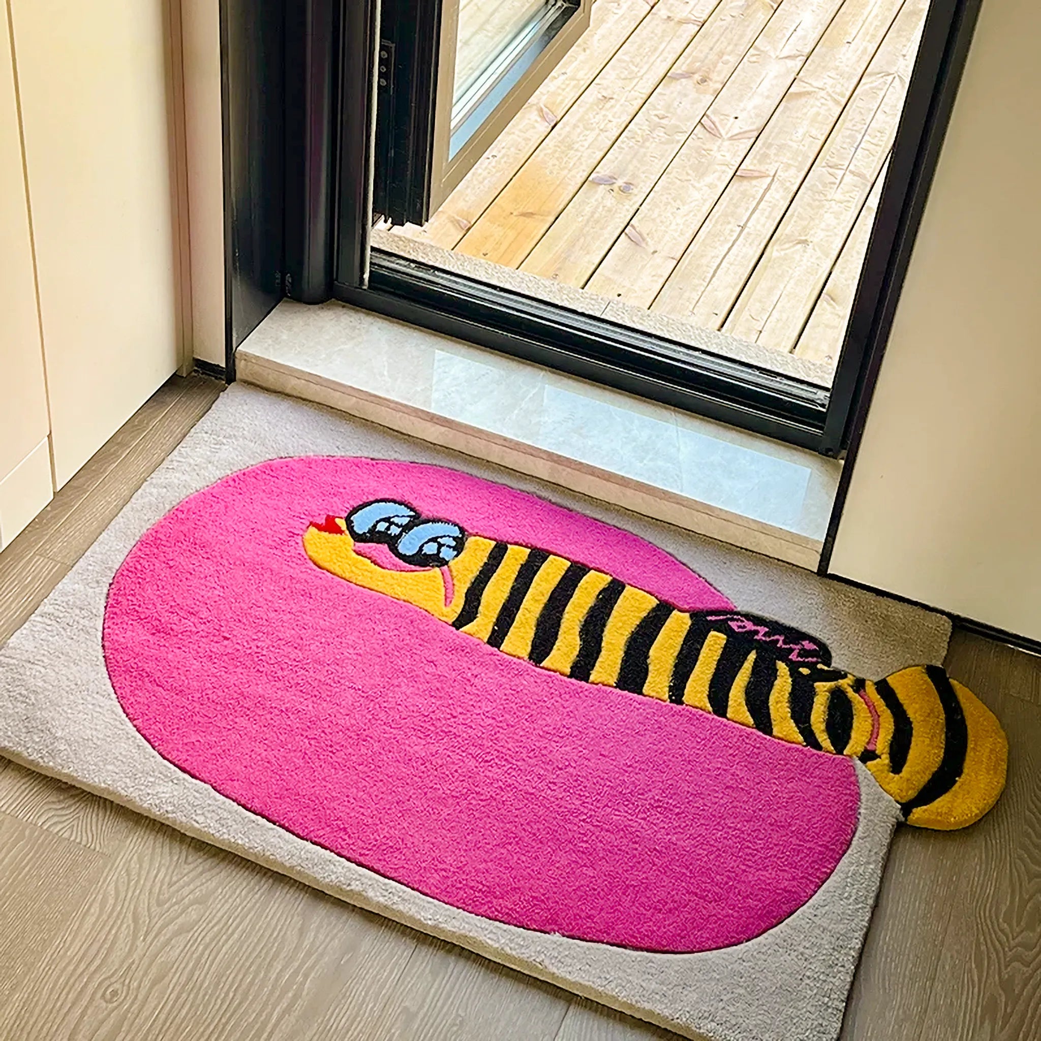 Denny Pink Sea Yellow Clownfish Graphic Tufted Rug by Housenfriends, hot pink oval sea rug with yellow clownfish, black stripes and protruding tail at doorway