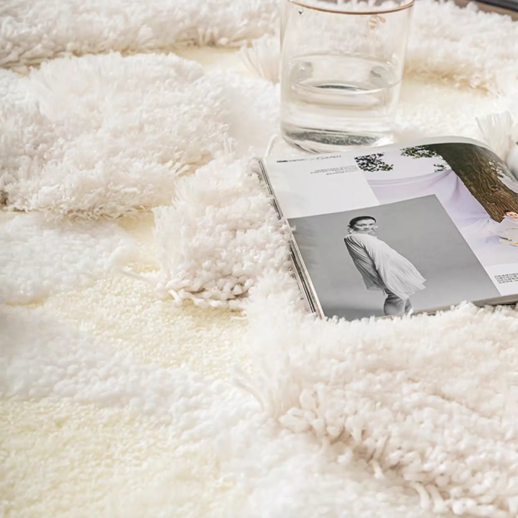 Eira Off White Irregular Cloud Patch High Low Tufted Rug by Housenfriends, with an open magazine and a glass resting on the plush high-low surface.