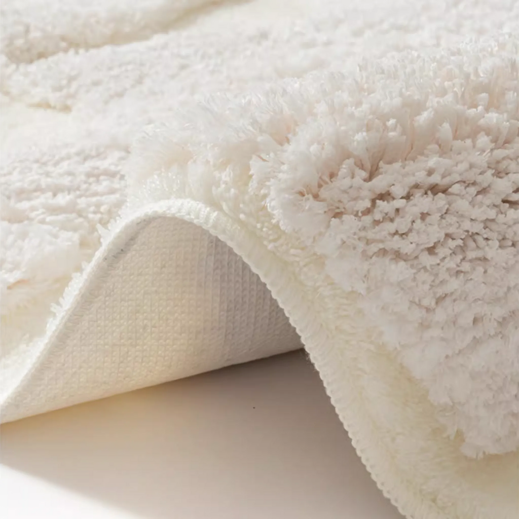 Eira Off White Irregular Cloud Patch High Low Tufted Rug by Housenfriends, corner lifted to show the thick tufted pile and the textured backing underneath.
