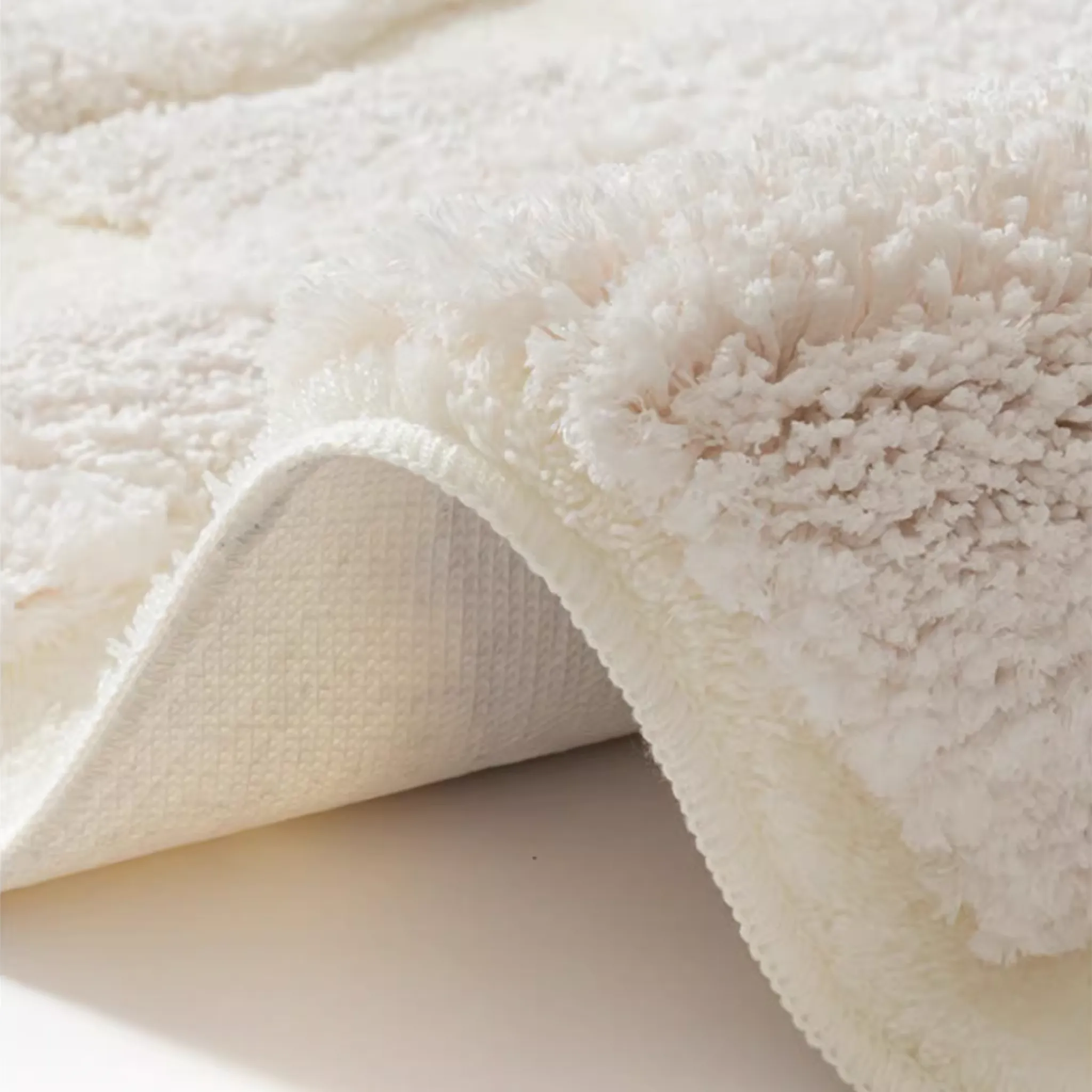Eira Off White Irregular Cloud Patch High Low Tufted Rug by Housenfriends, corner lifted to show the thick tufted pile and the textured backing underneath.