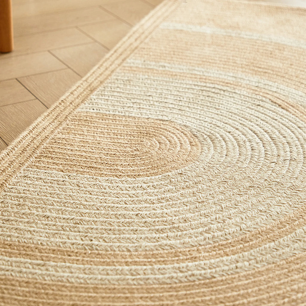 Close-up of Elina Beige & Natural Jute-Blend Braided Half Moon Rug on a wooden floor