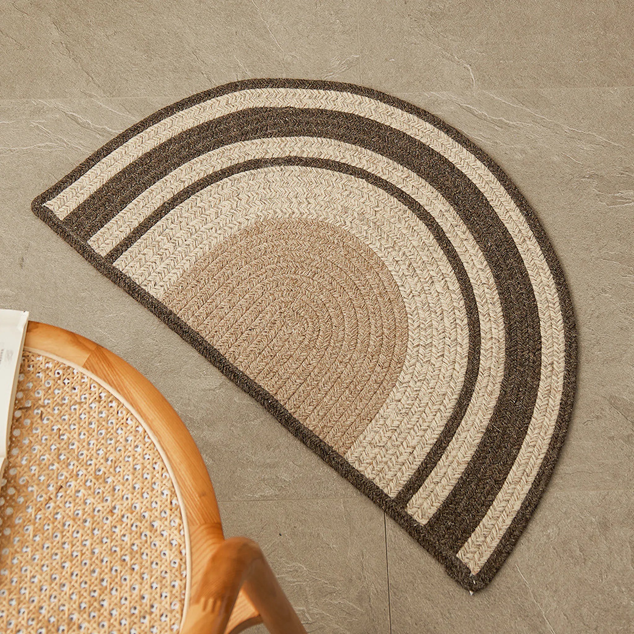 Elina Brown & Beige Wool-Blend Braided Half Moon Rug on a stone floor.