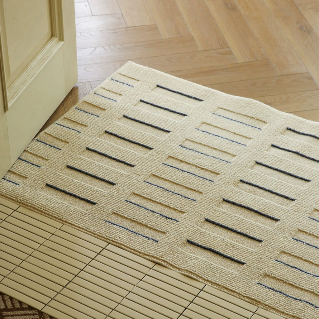 Housenfriends Elio Beige & Navy Striped High-Low Textured Rug placed by doorway as an entry rug