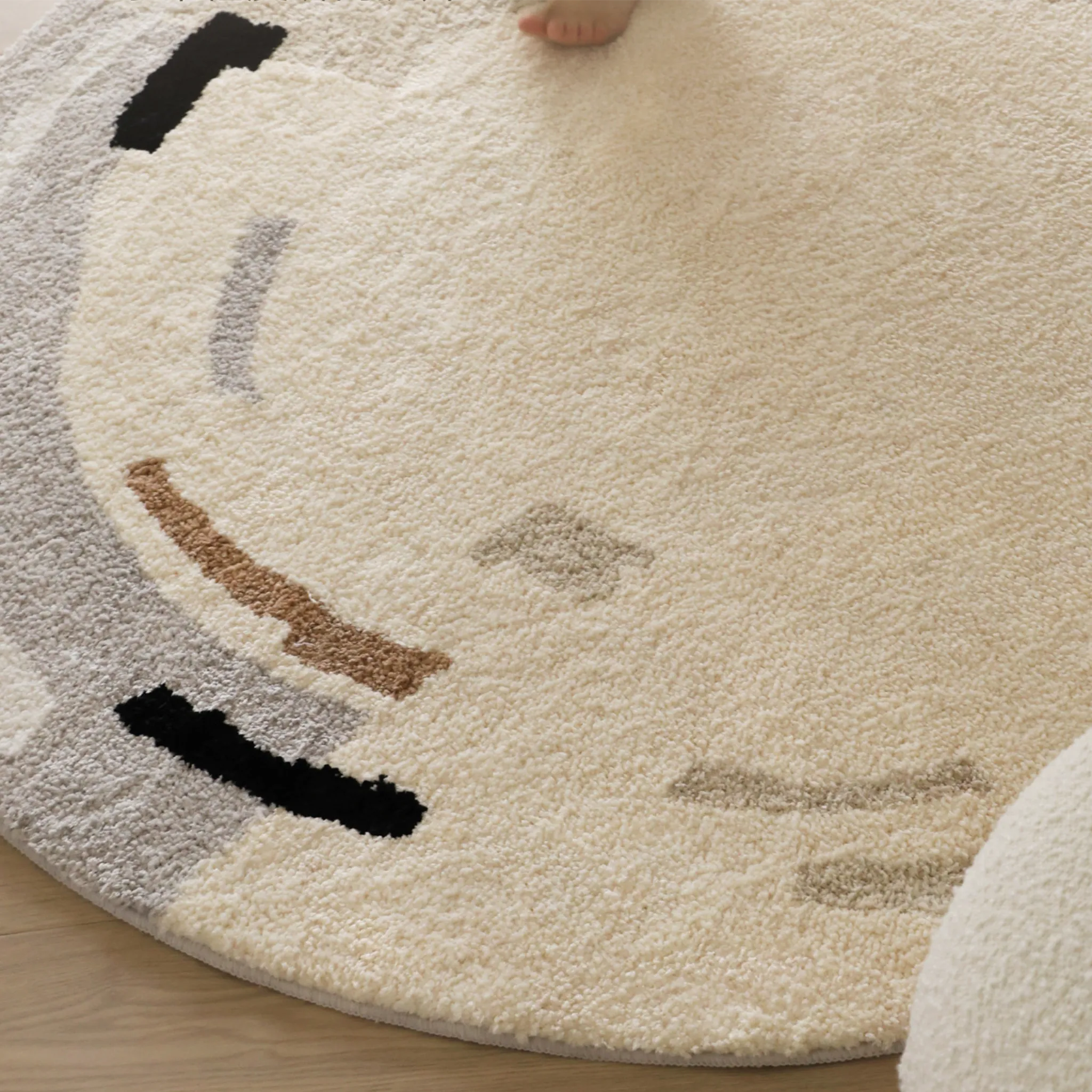 Elodie Cream & Beige Abstract Circle Round Tufted Rug Housenfriends close-up detail showing beige, grey and black abstract circle accents on cream base