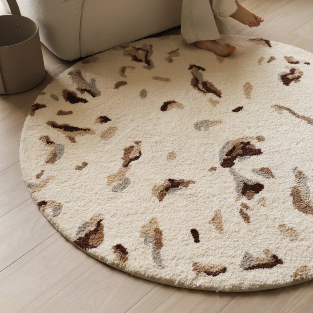 Elodie Cream & Brown Abstract Speckled Round Tufted Rug Housenfriends styled under sofa in a small living room, neutral round tufted rug with abstract speckles