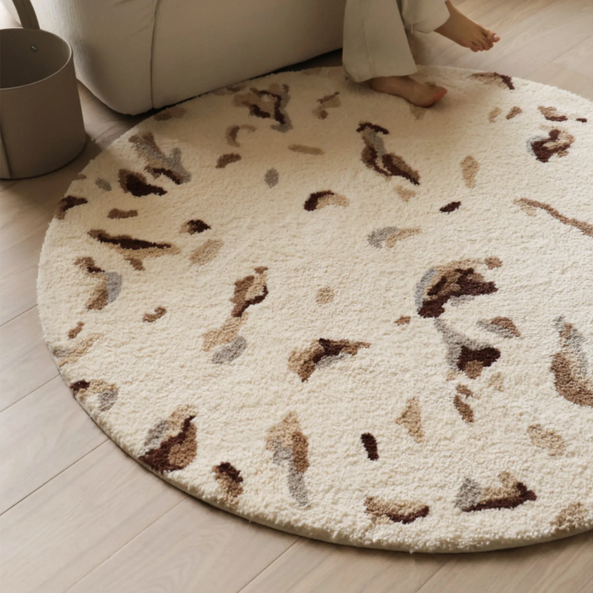 Elodie Cream & Brown Abstract Speckled Round Tufted Rug Housenfriends styled under sofa in a small living room, neutral round tufted rug with abstract speckles