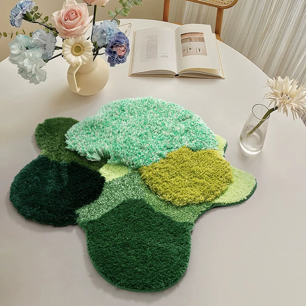 Elowen Mint Green Woodland High Low Tufted Irregular Rug on a table with flowers and an open book in the background