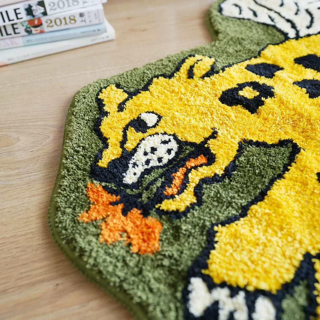 Close up of Faye yellow winged leopard rug with orange flower detail, black spots and soft olive green tufted texture