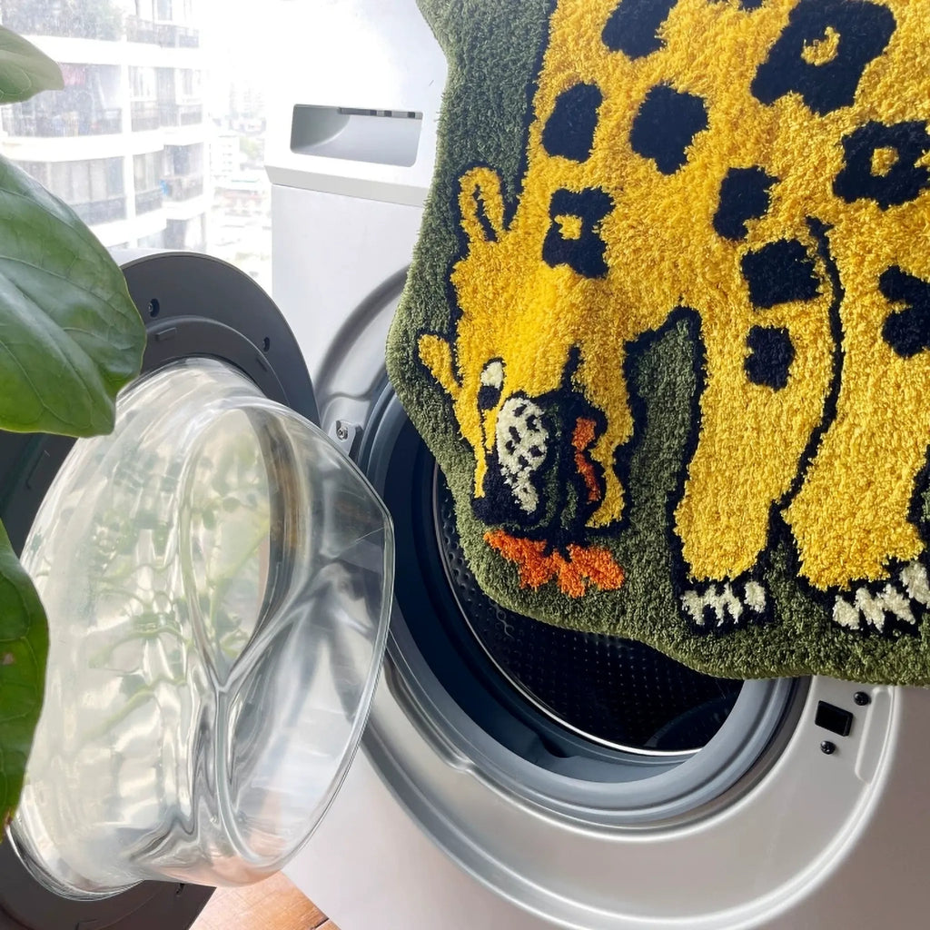 Machine washable yellow and olive green winged leopard rug by Housenfriends, shown beside a washing machine