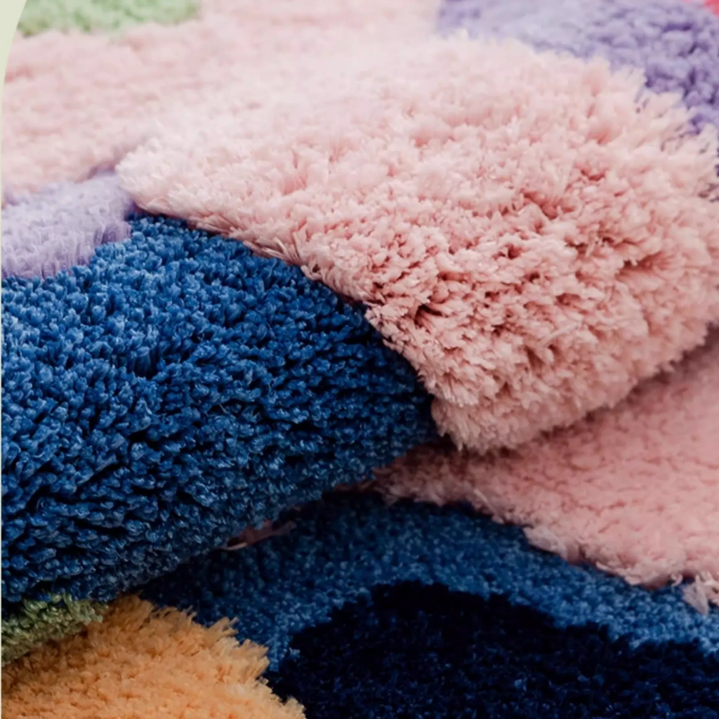 Freya multicolour moss green abstract floral high low tufted rug close-up, fluffy blush high pile over deep blue base, carved texture and cloud-soft underfoot feel