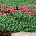 Model figures of people working in a field with a water dropper on a textured surface.