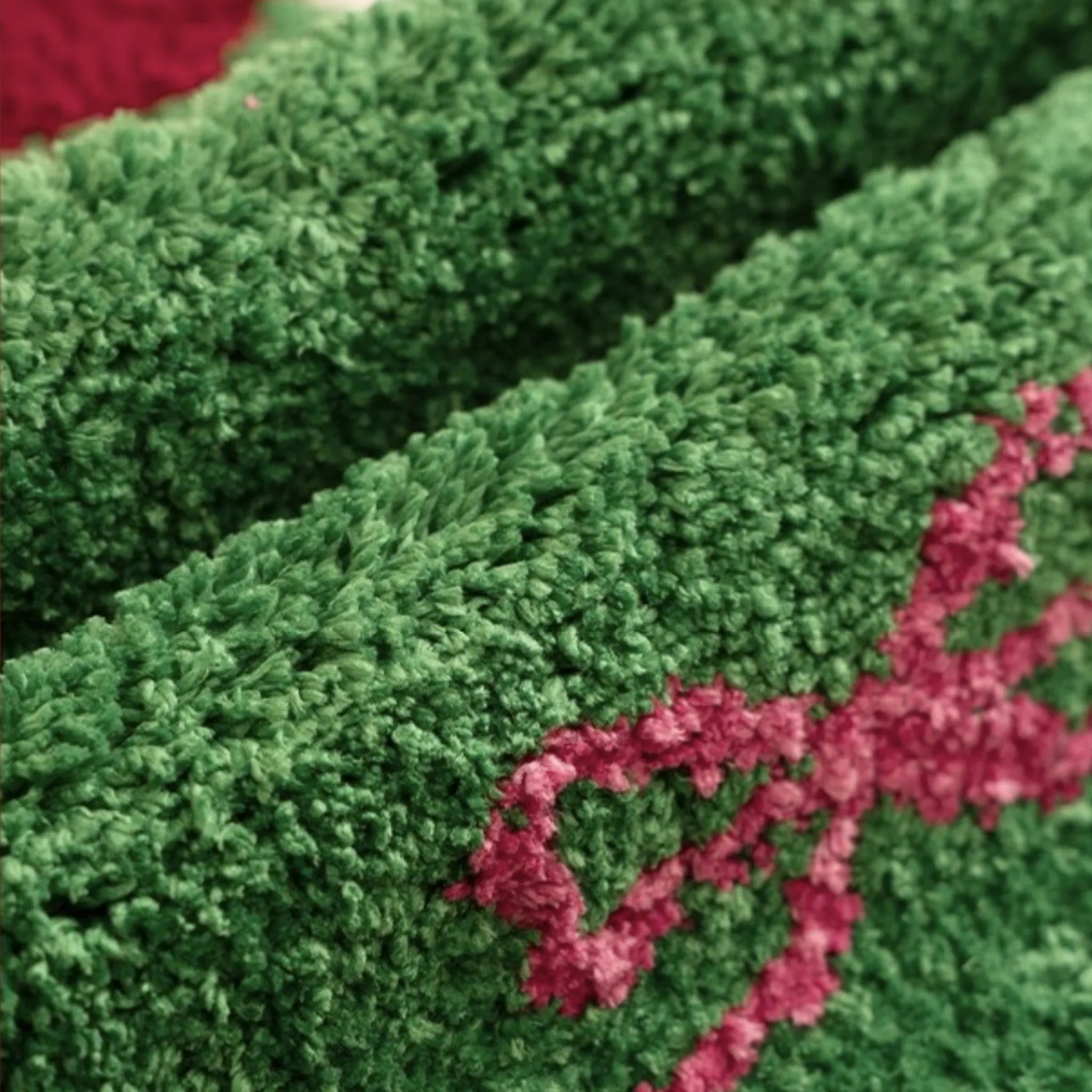Close-up of green textured fabric with pink ribbons from Sprout Green Tree Shaped Tufted Rug by Housenfriends