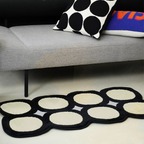 Harper Black and White Irregular Polka Dots Tufted Rug by Housenfriends on floor with a sofa and pillows.