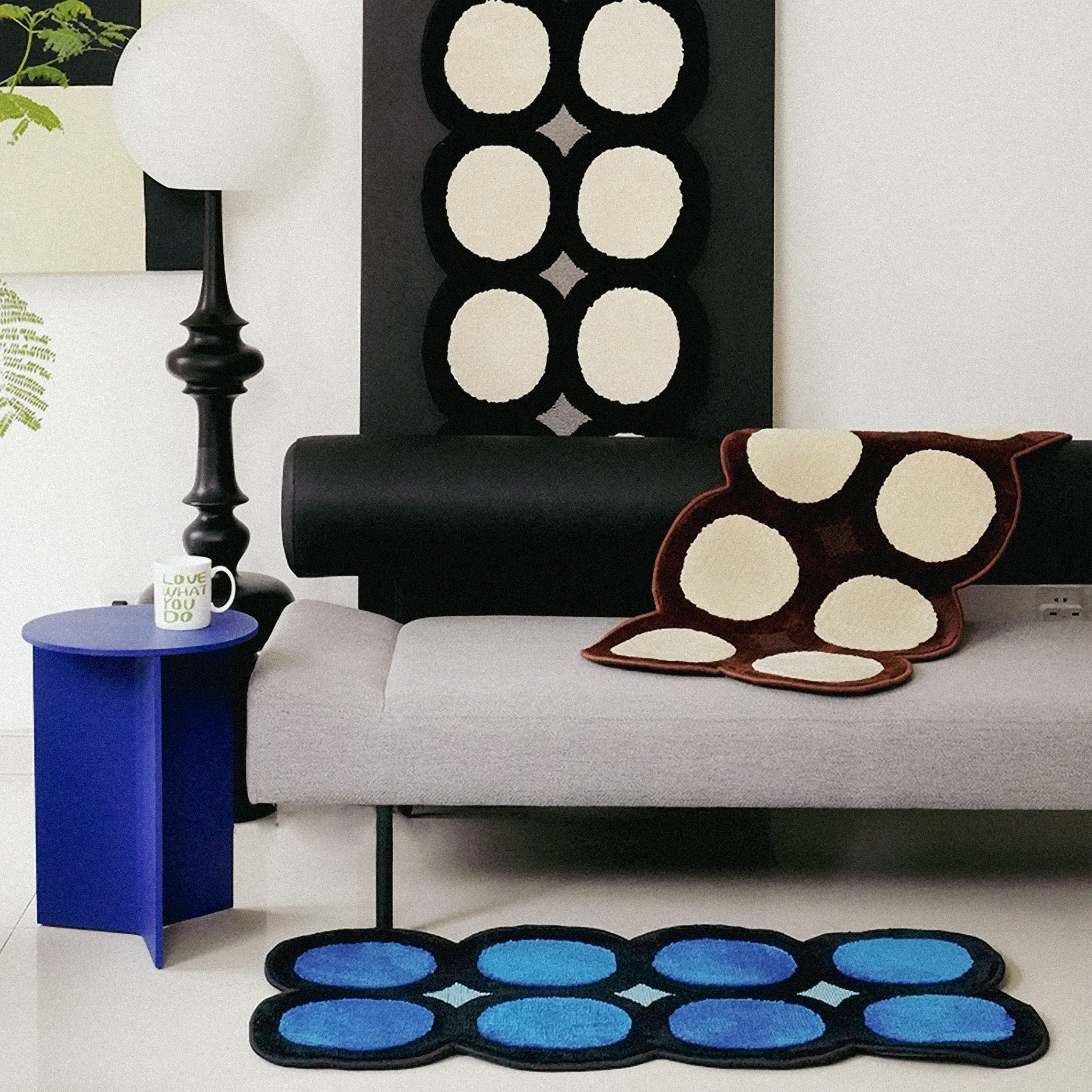 Modern living room with a black chair, grey sofa, and three Harper Irregular Polka Dots Tufted Rugs by Housenfriends.