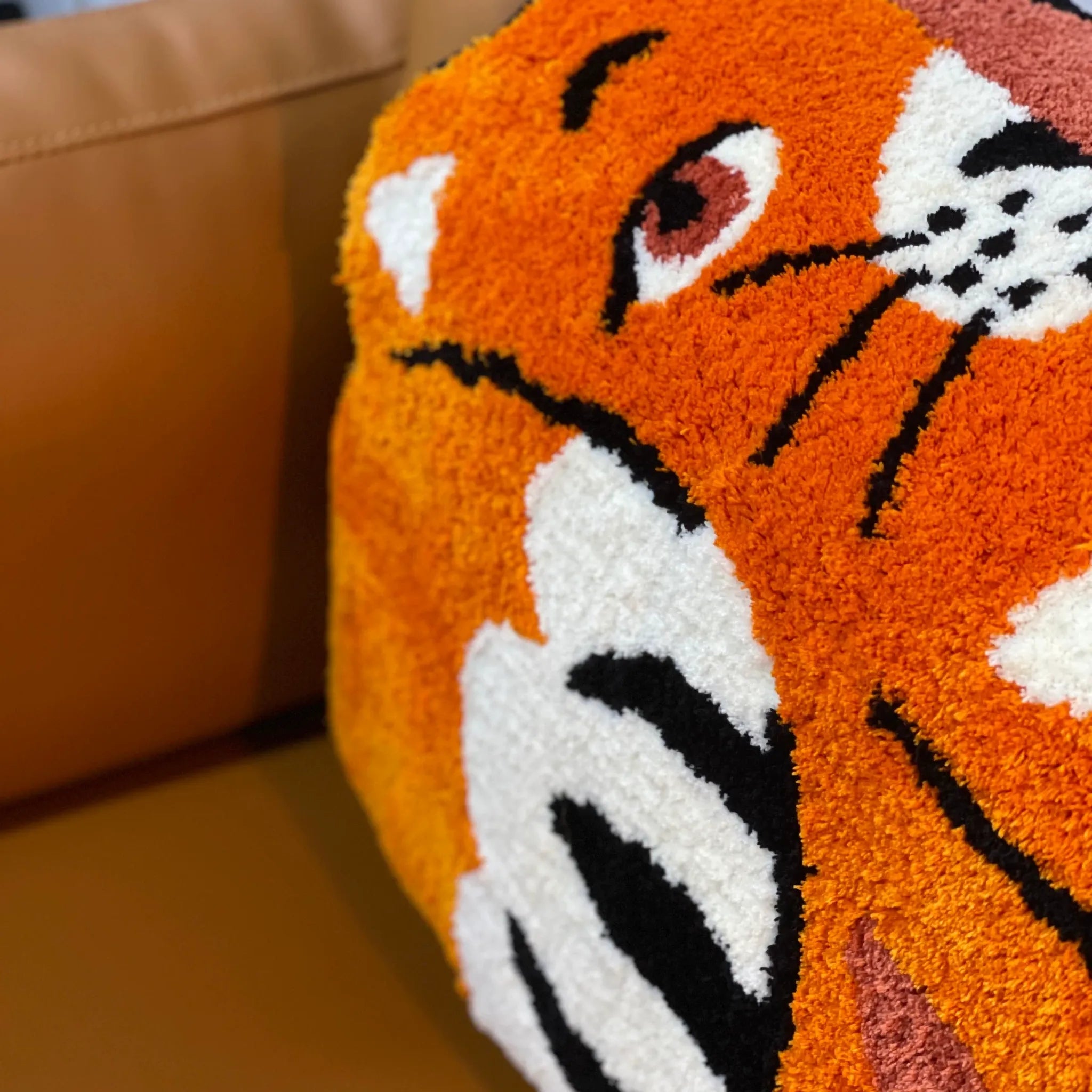 Close up of Hide and Seek orange patchwork cat rug with soft tufted texture and black white face details