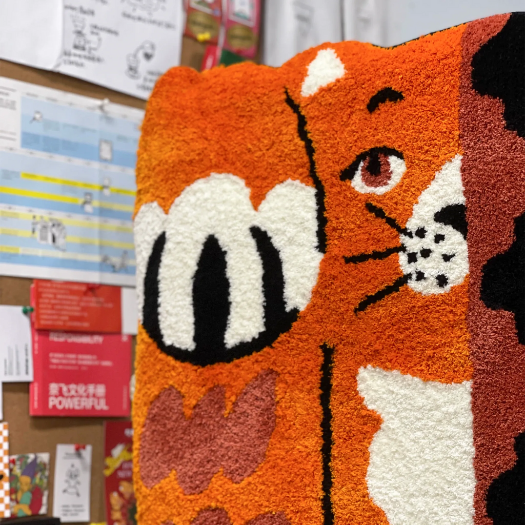Hide and Seek orange patchwork cat shaped rug close up with one eye, black markings and bold tufted pile by Housenfriends