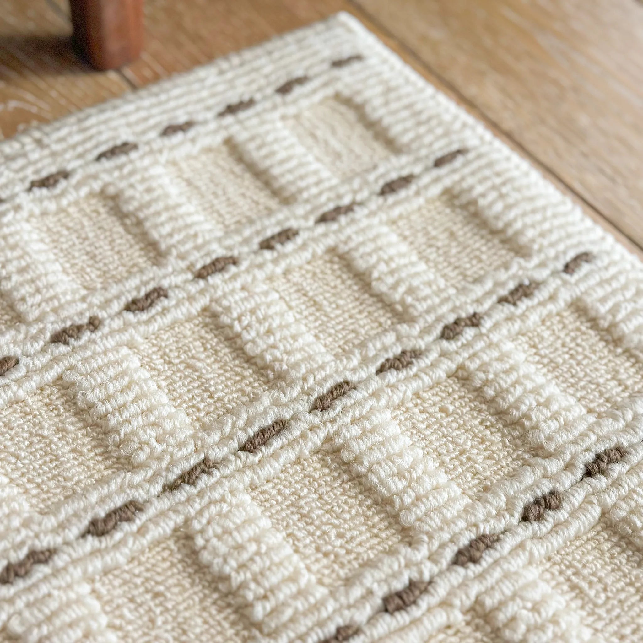 Housenfriends Ivo rug close-up showing cream mocha stitch-grid pattern and dense loop high-low texture