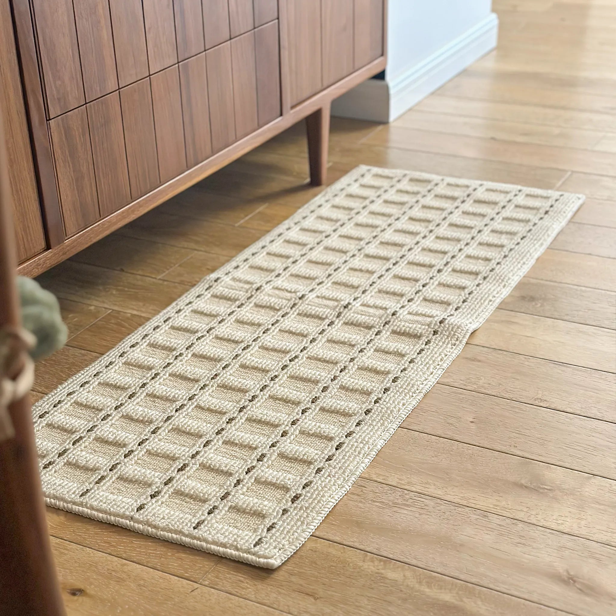 Housenfriends Ivo cream mocha grid textured runner rug styled beside wooden cabinet in hallway