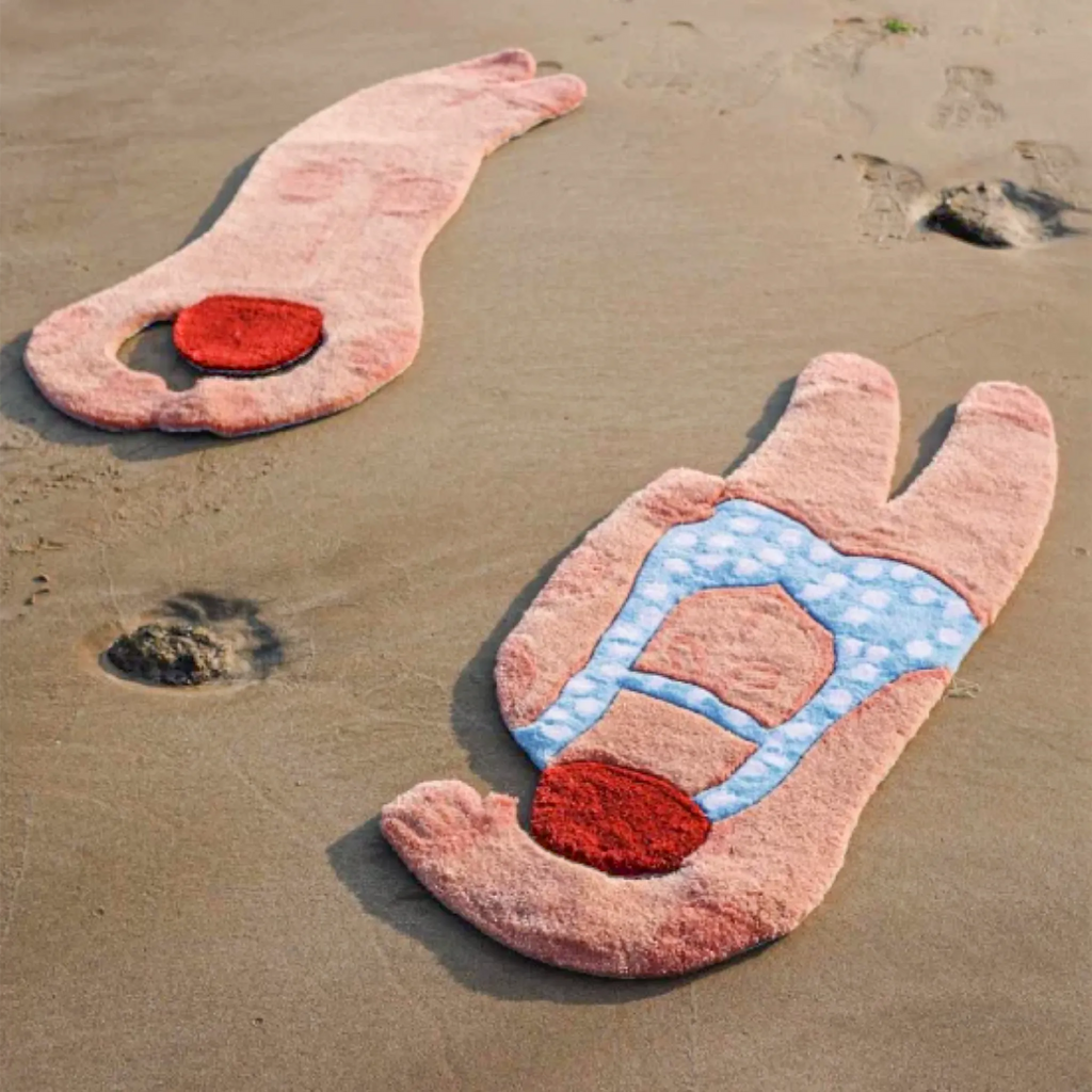 June seaside swimming girl graphic body art rugs by Housenfriends on sand, showing pale blue polka dot, navy swimsuit and nude curved back tufted rug designs