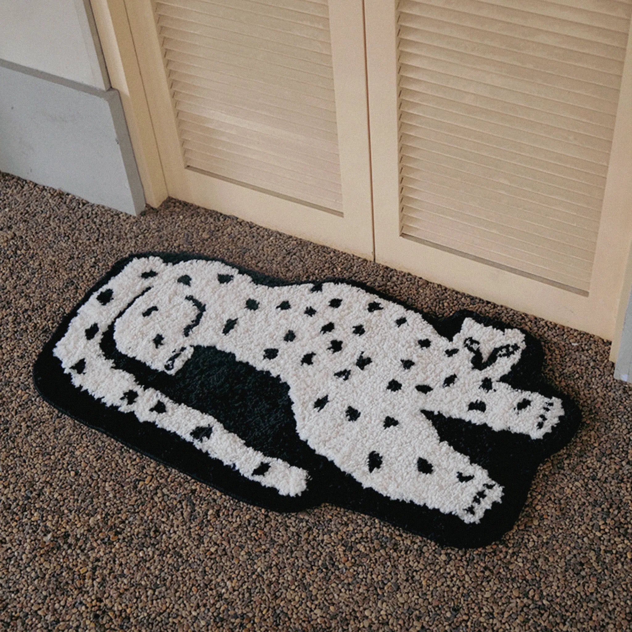 Layla Black Base White Leopard Shaped Tufted Rug on a carpeted floor.