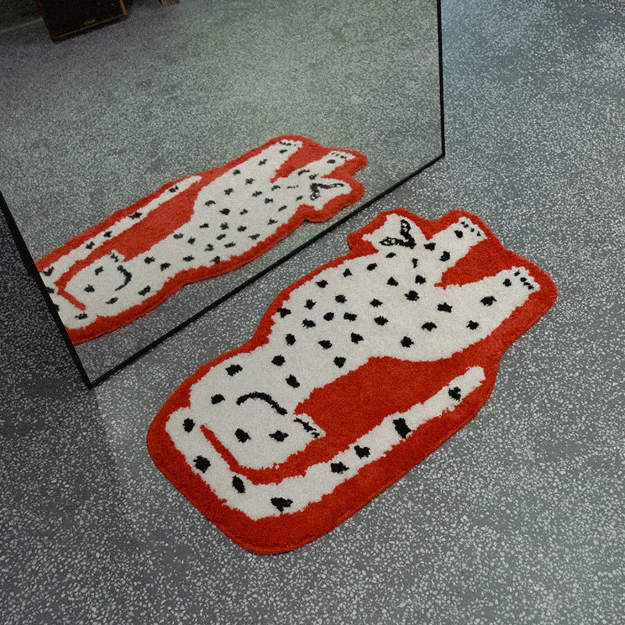 Layla Red Base White Leopard Shaped Tufted Rug in front of a mirror on a grey floor.