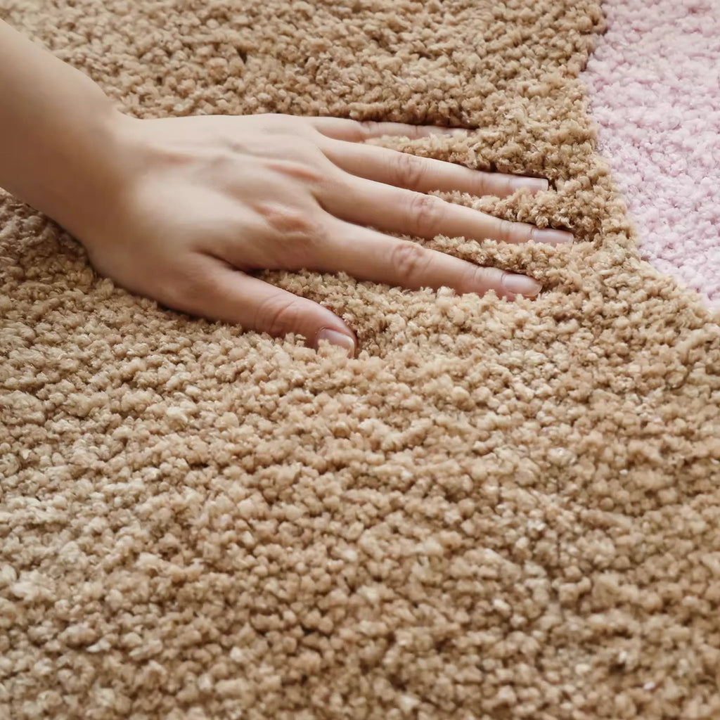 Hand touching Maisie Beige & Blush Pink Floral Shaped Tufted Rug by Housenfriends, daisy rug small rug with dense tufted pile and soft blush