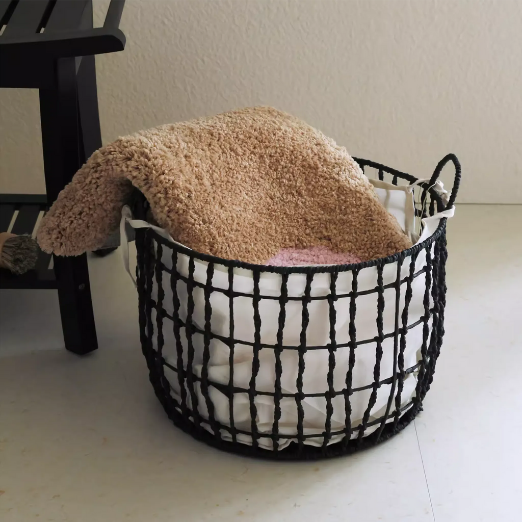 Maisie Beige & Blush Pink Floral Shaped Tufted Rug folded in a basket, soft small rug from Housenfriends