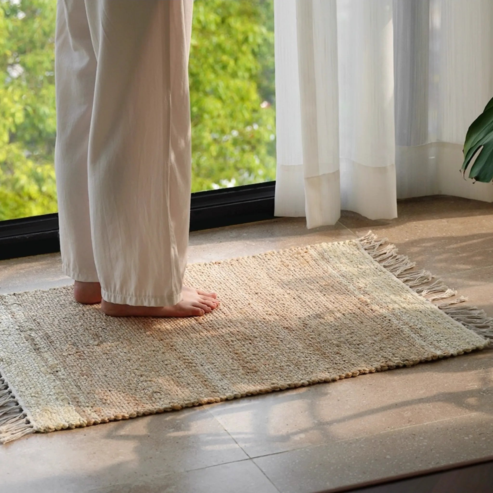 Maren Natural & Oat Fringed Handwoven Jute Rug by Housenfriends, natural jute texture in bright room setting