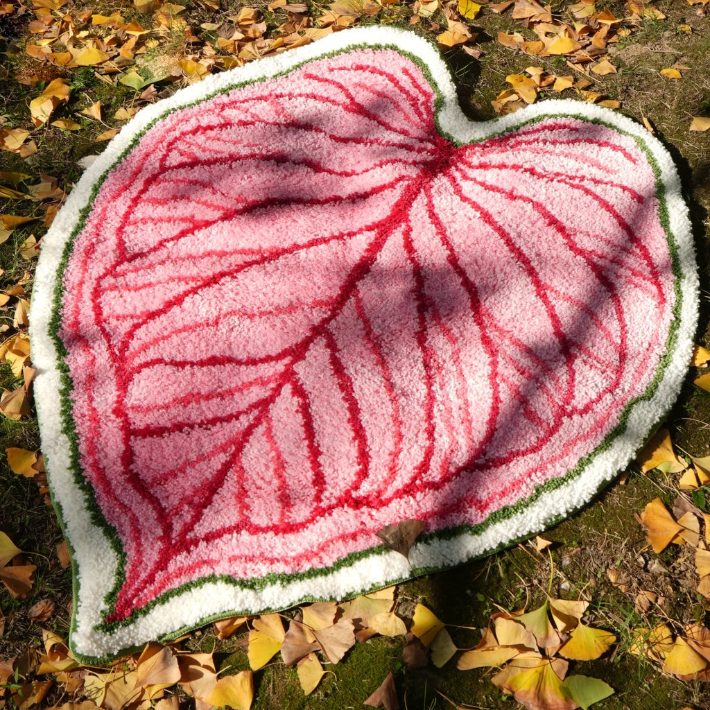 Mina pink heart leaf shaped rug outdoors on fallen leaves, botanical tufted rug with raised red veins and green white edge by Housenfriends
