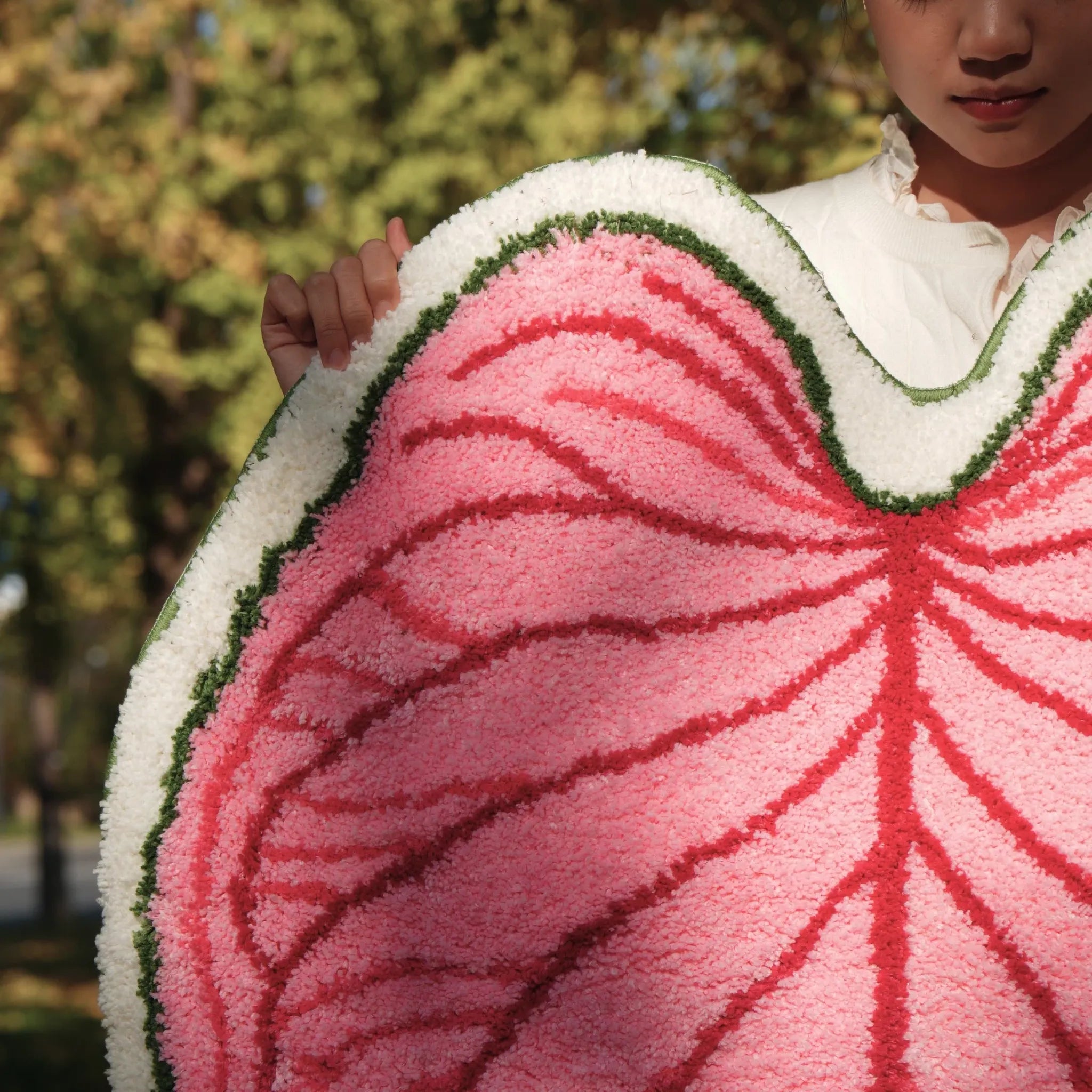Close-up of Mina pink botanical heart leaf shaped tufted rug with raised red veins and thick green white edge by Housenfriends