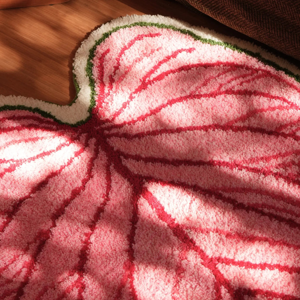 Close-up of Mina pink botanical heart leaf shaped tufted rug with raised red veins, green white border and textured pile by Housenfriends