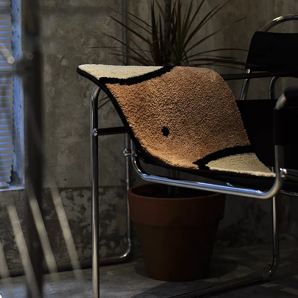 Nico Beige & Tan graphic abstract waist body art tufted rug draped over a modern chair, showing navel detail, Housenfriends