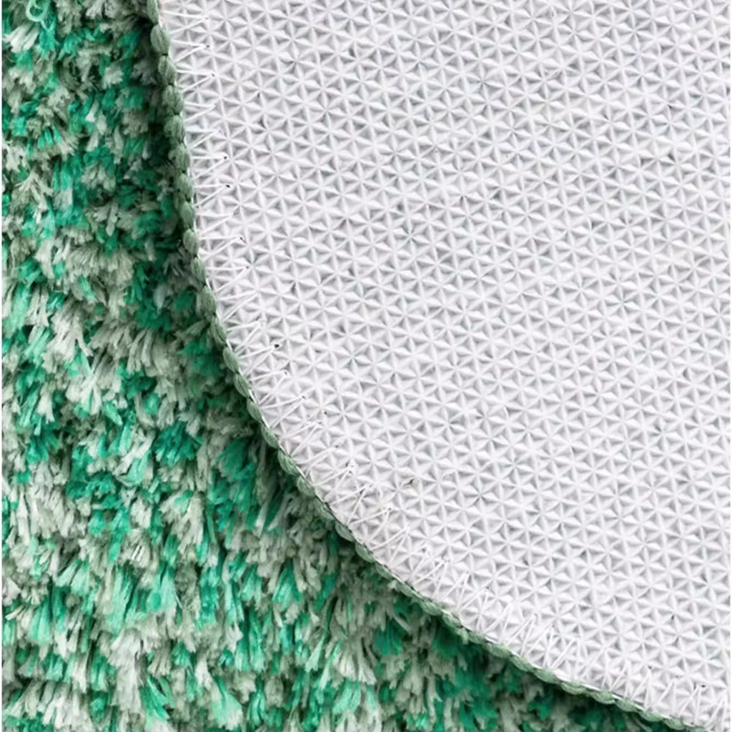 Close-up of Elowen Mint Green Woodland High Low Tufted Irregular Rug and its white non-slip backing