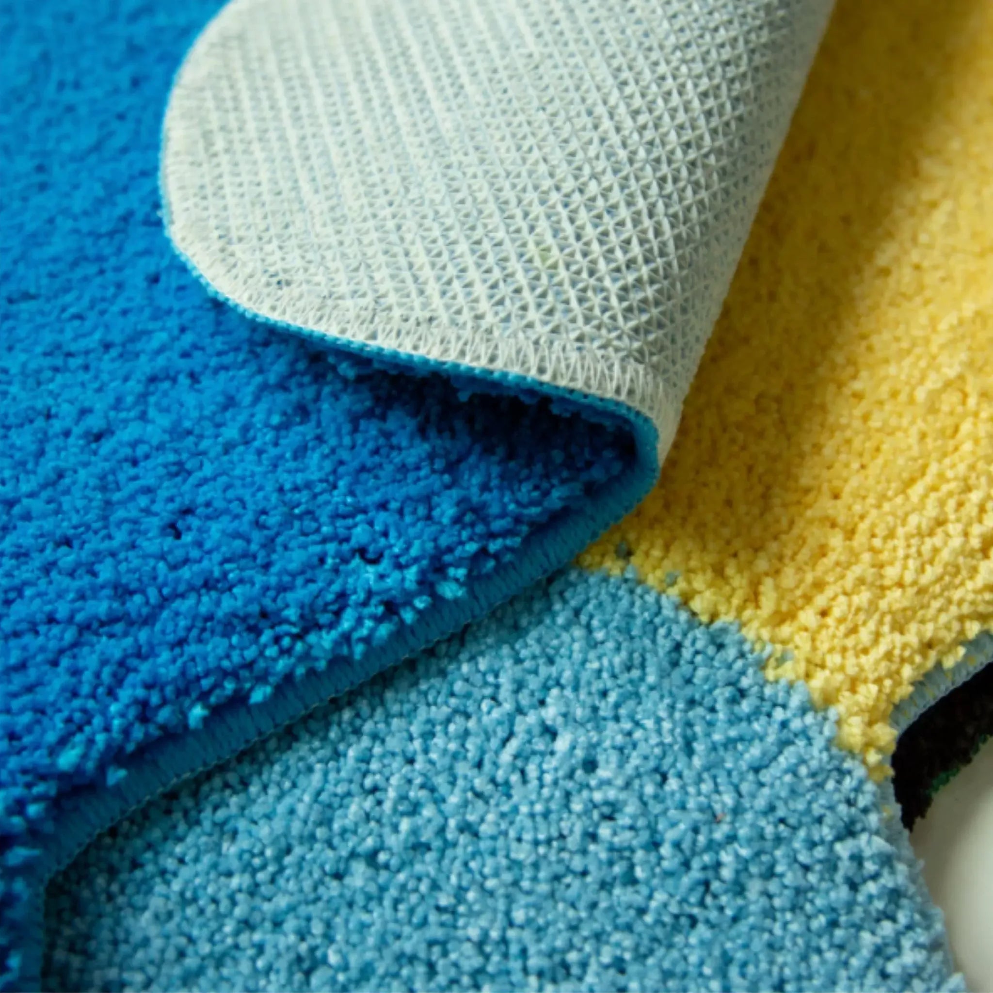 Pip Happy Holiday Graphic Car Shaped Tufted Rugs by Housenfriends close up, soft shaggy pile with non-slip backing in blue, yellow and pale blue details