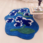 Orla blue and green floral shaped high-low tufted small rug (80×120cm) styled on the floor, organic outline and bold blue base