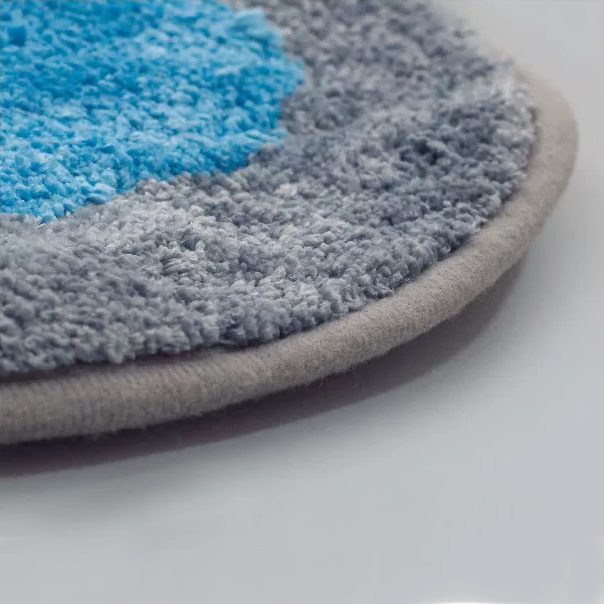 Close-up of Otto orange dog and blue cat tufted rug by Housenfriends with dense pile, grey bound edge and non-slip cotton backing