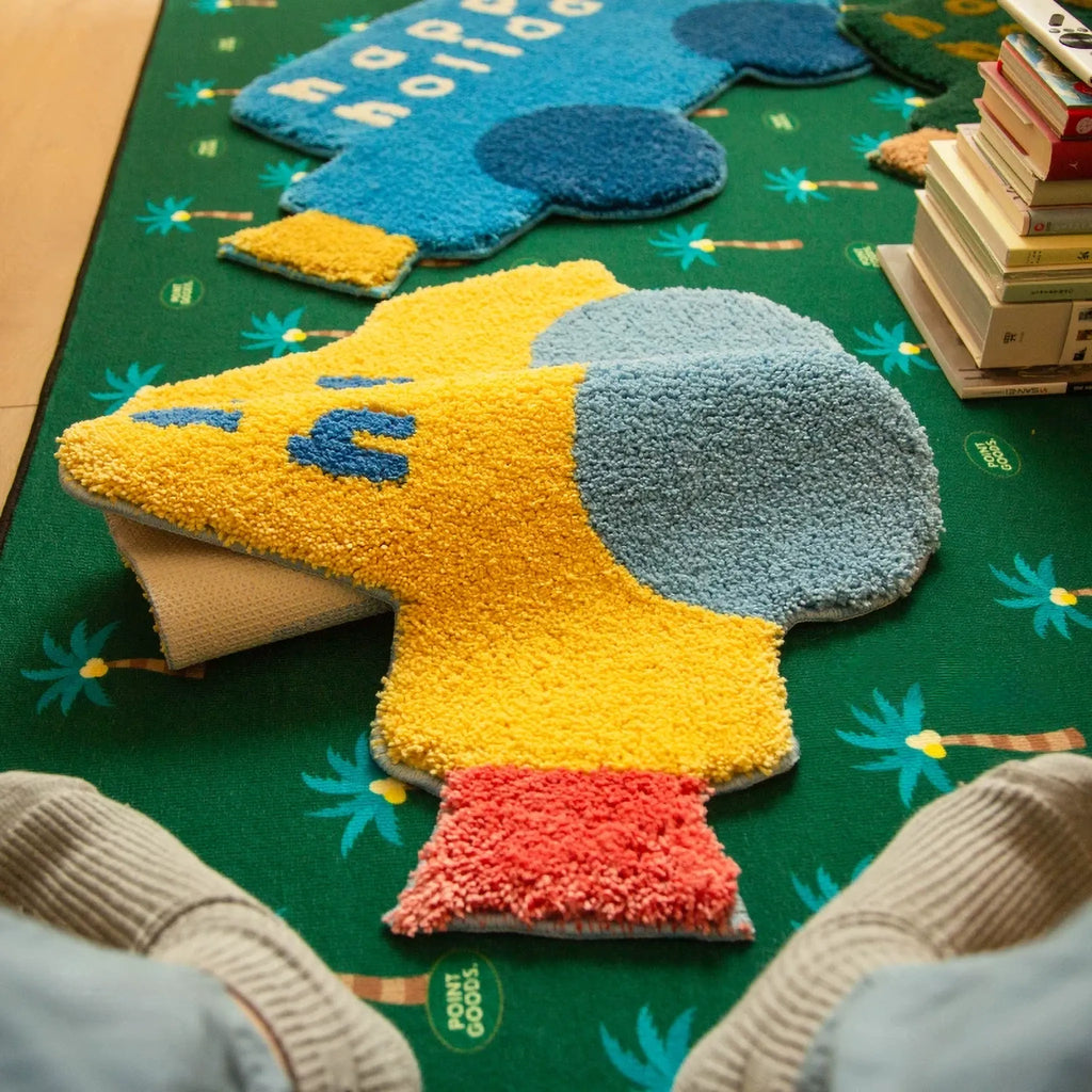 Pip Yellow & Blue Happy Holiday Graphic Car Shaped Tufted Rug by Housenfriends, colourful car shaped rug with blue wheels and playful word art on green floor