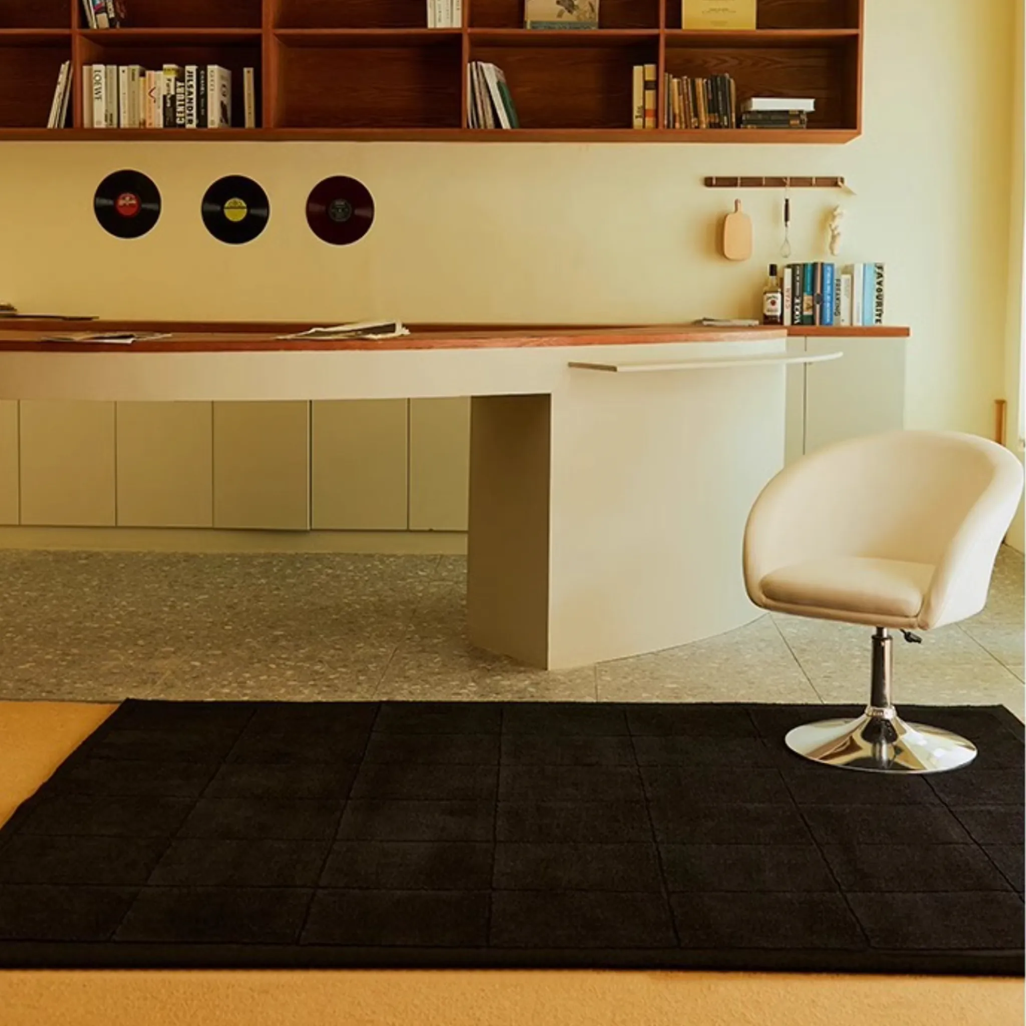 Modern home office with a desk, chair, bookshelf and Pure Black Minimalist Modern Hand Tufted Rug by Housenfriends.