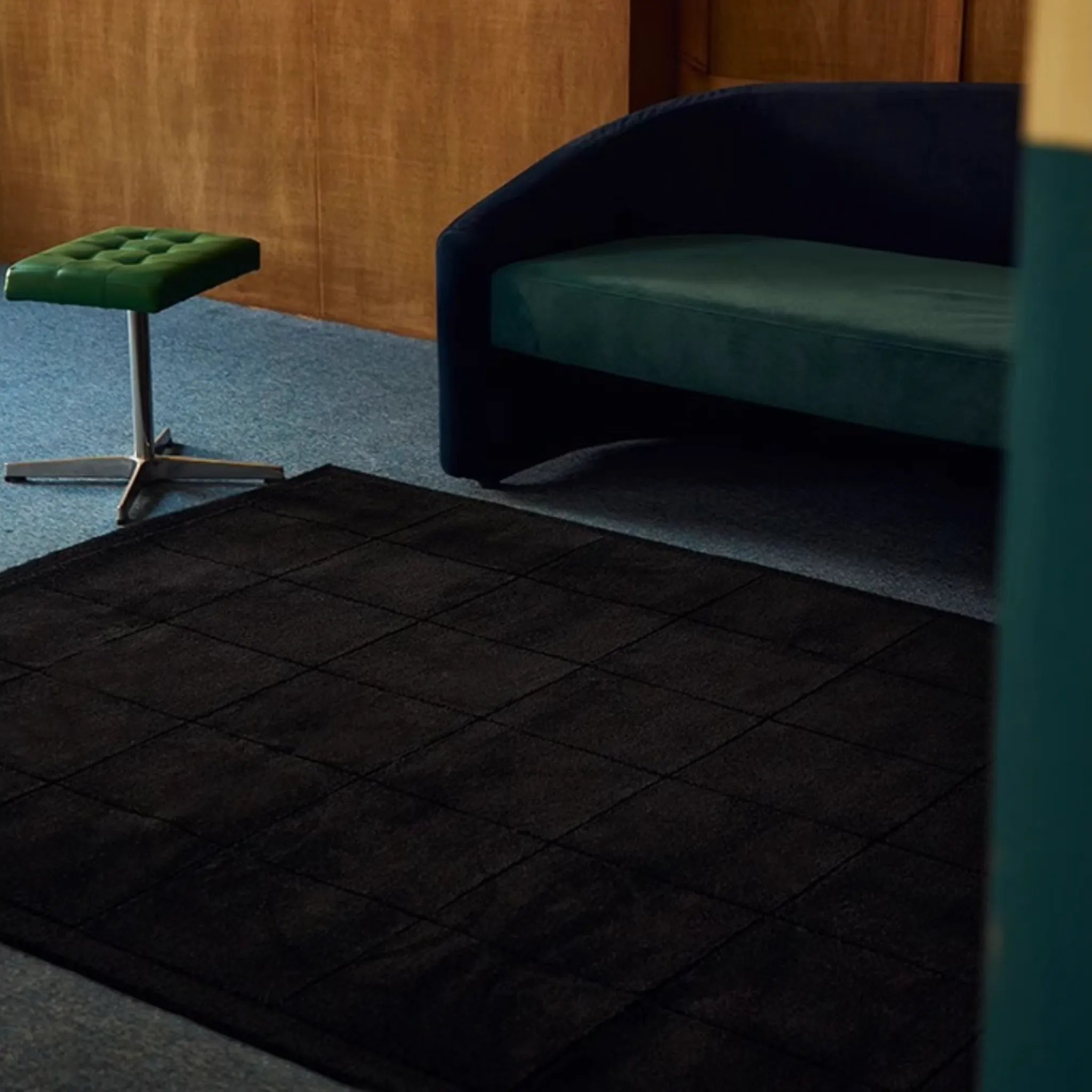 Pure Black Minimalist Modern Tufted Rug by Housenfriends with a green stool and teal sofa.