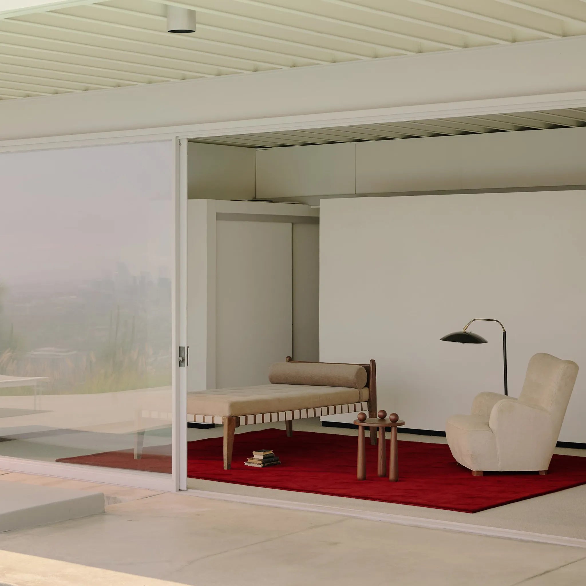 Modern living room with a Burgundy Diamond Modern High Low Hand Tufted Rug, beige armchair, and wooden bench.