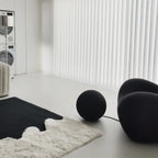 Modern interior with black spherical objects and Reynisfjara Black Shore White Abstract Rug by Housenfriends on floor.
