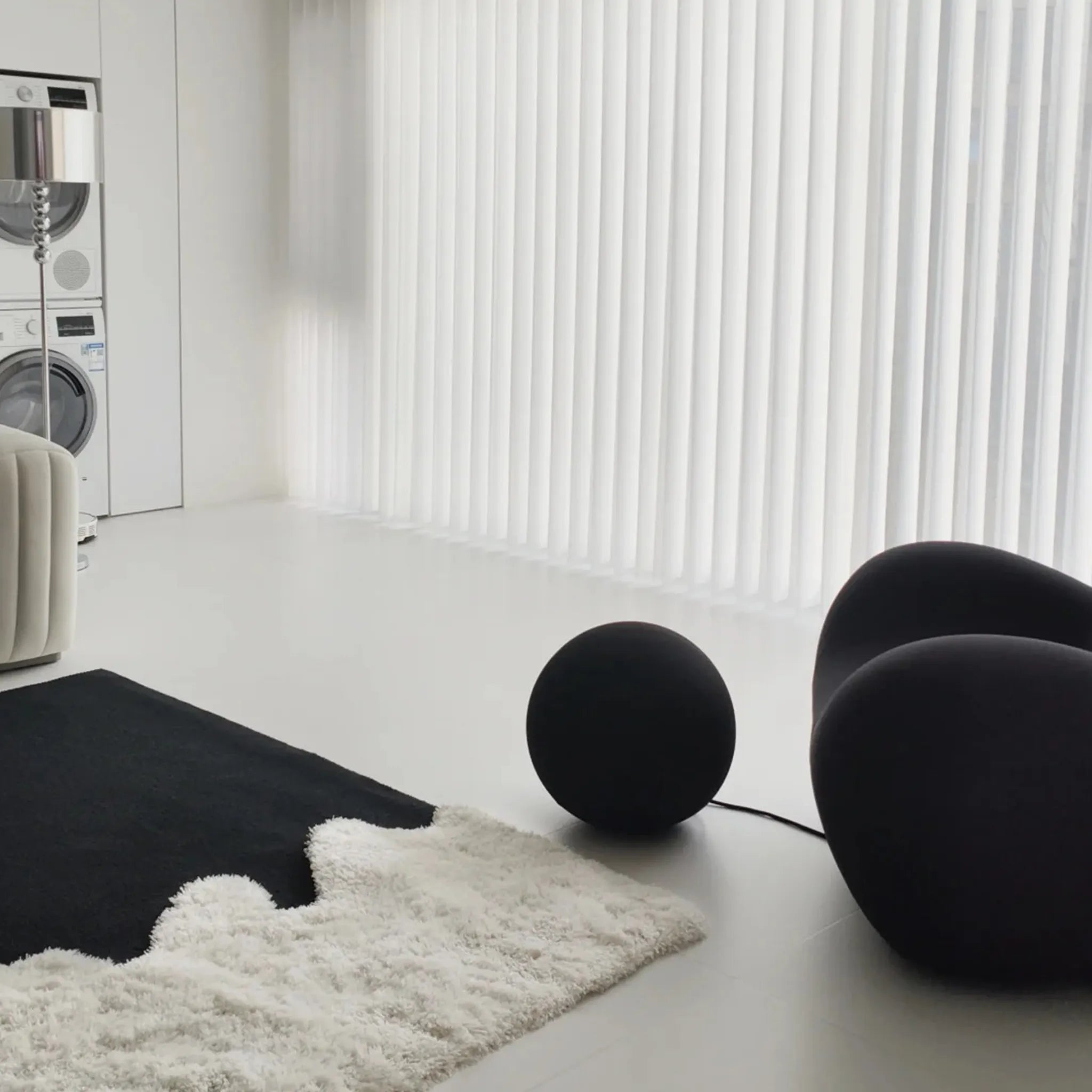 Modern interior with black spherical objects and Reynisfjara Black Shore White Abstract Rug by Housenfriends on floor.