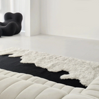 Reynisfjara Black Shore White Waves Abstract High Low Rug by Housenfriends on a white floor with a modern chair and sofa.