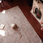 Rowan Neutral Multi-Tone Wool & Jute Handwoven Classic Rug on a wooden floor with a fireplace