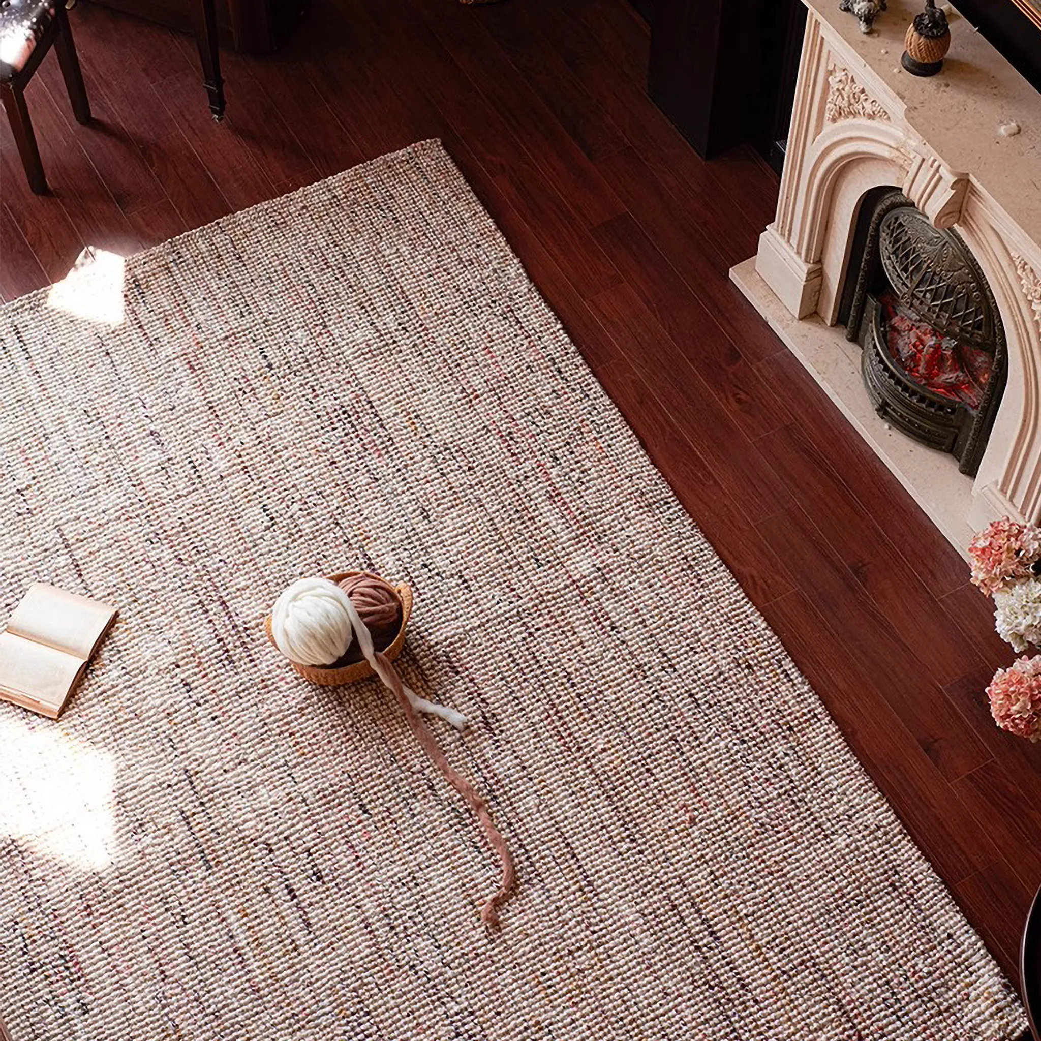 Rowan Neutral Multi-Tone Wool & Jute Handwoven Classic Rug on a wooden floor with a fireplace