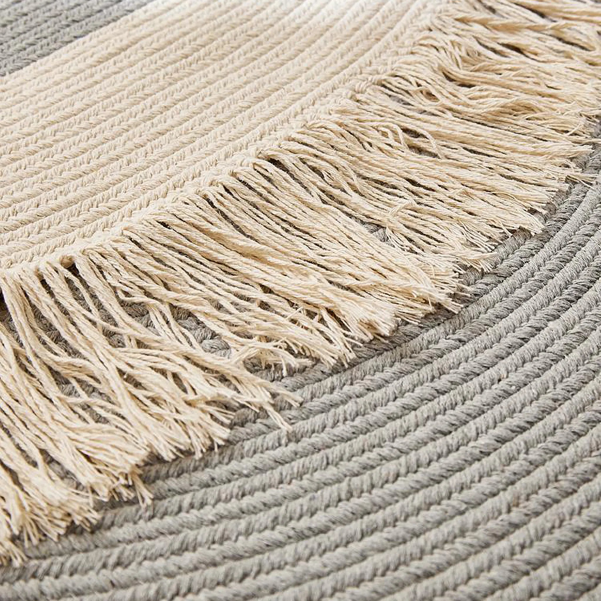 Signe grey and natural hand-braided cotton blend rug close-up showing fringe detail and braided texture by Housenfriends