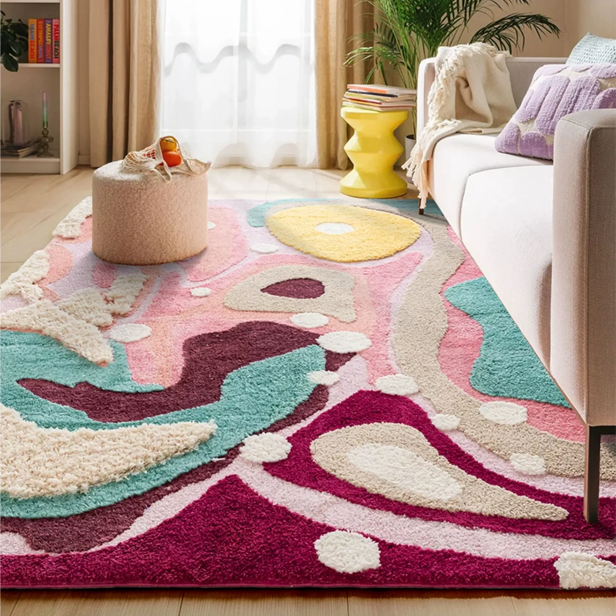 Willa pastel abstract high low tufted rug styled in a living room with a sofa, yellow side table and soft aqua, pink and berry tones